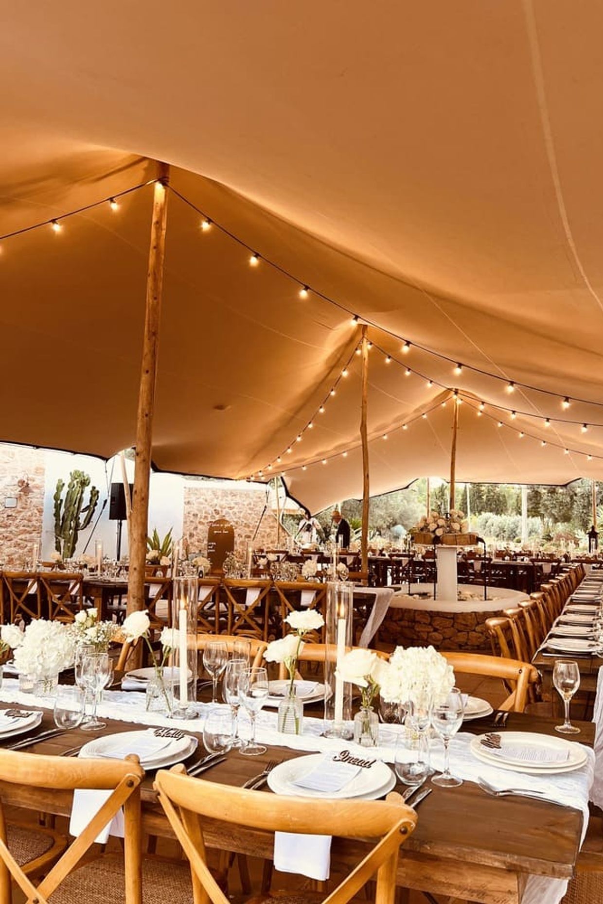 Wedding Venue In ibiza, dinner set up with wooden tables and white flowers and decoration